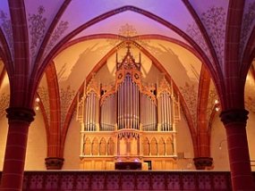 Eine Orgel mit bunter Hintergrundbeleuchtung mit einem Kirchengewölbe